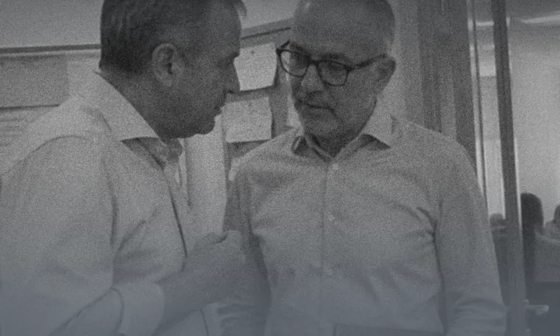 Two senior colleagues talking quietly in an office