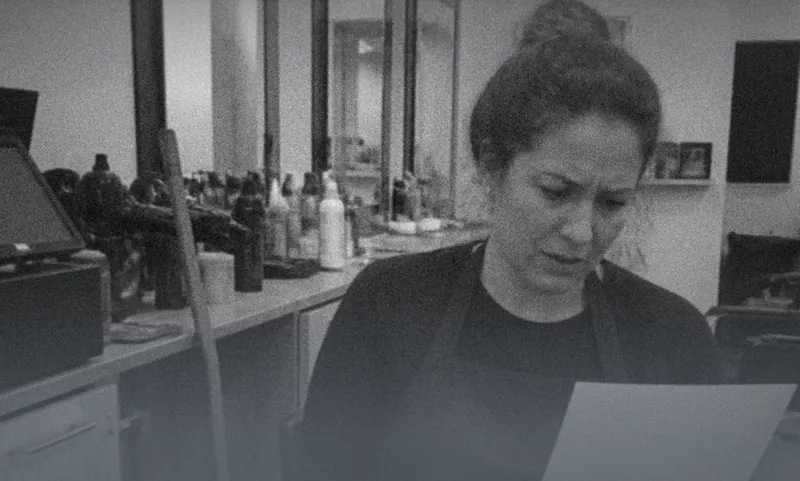 A woman in a salon reading a letter