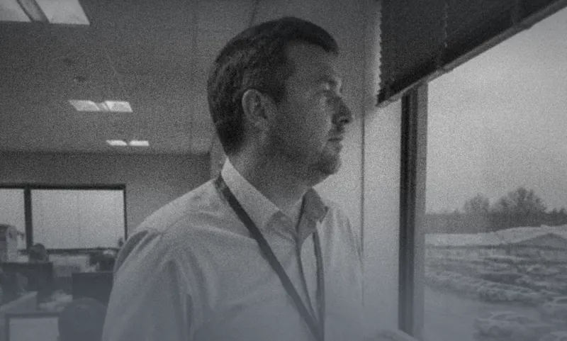 A man in an office looking out of the window